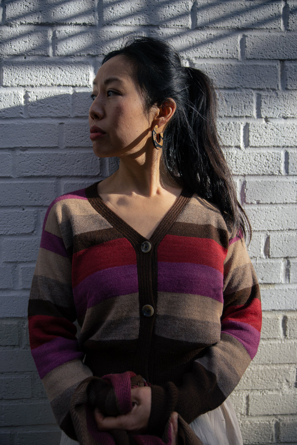 Atardecer Alpaca Cardigan — striped alpaca knit in earthy brown, taupe, crimson, and violet, inspired by Andean sunsets.