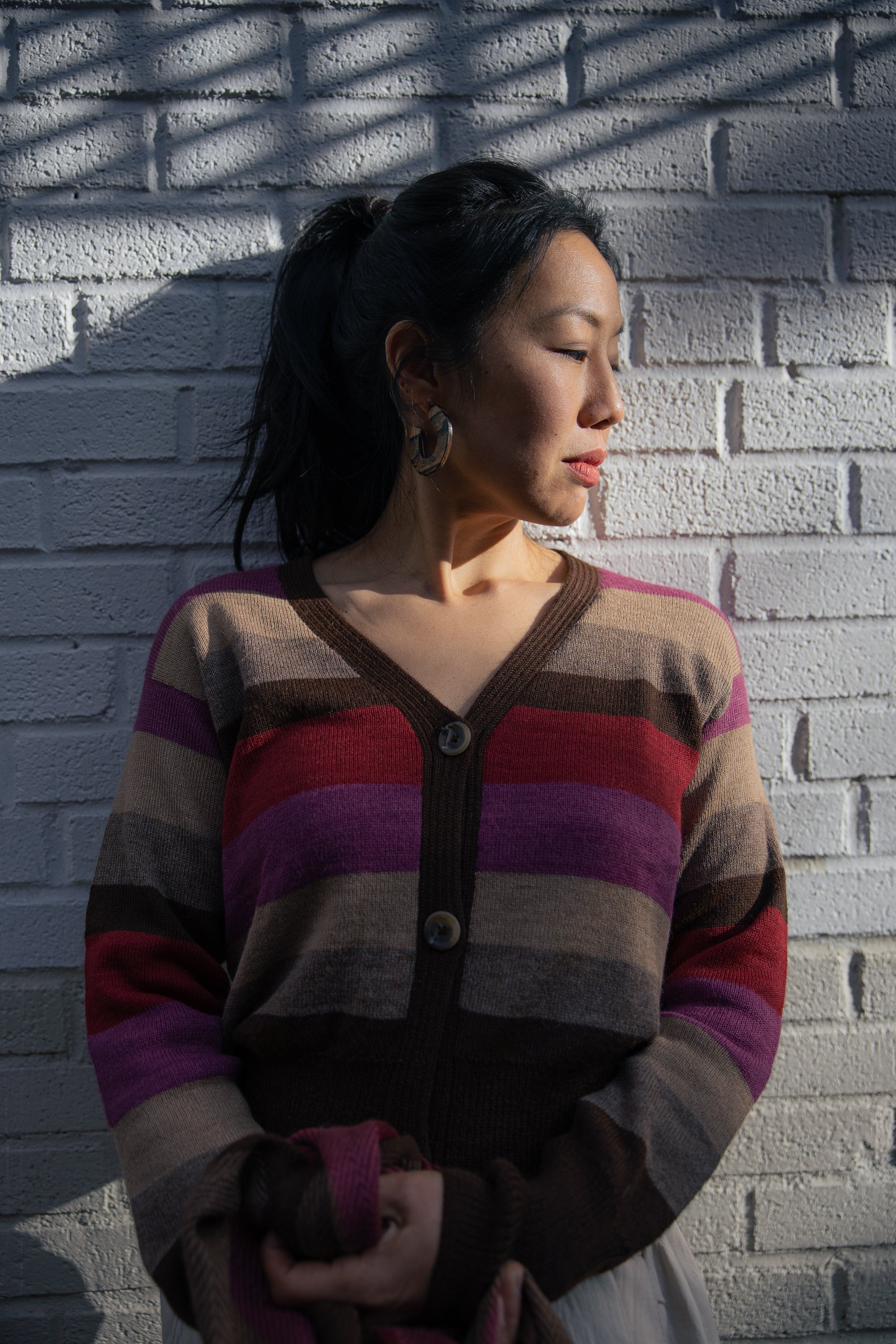 Atardecer Alpaca Cardigan — striped alpaca knit in earthy brown, taupe, crimson, and violet, inspired by Andean sunsets.