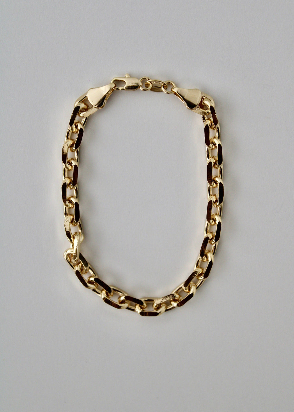 Gold knife-edge chain bracelet on a white background