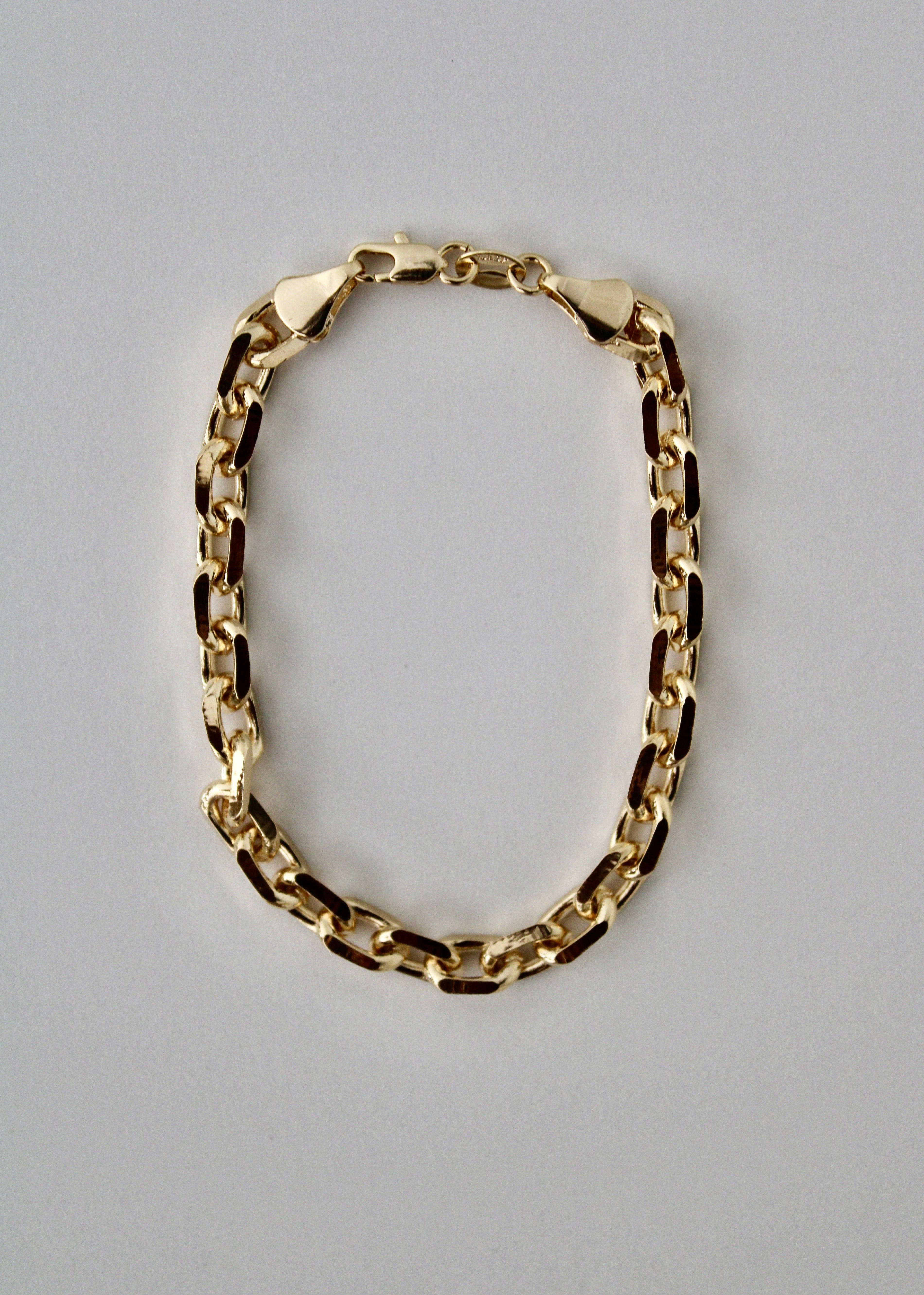 Gold knife-edge chain bracelet on a white background