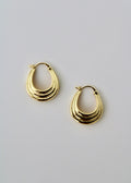 Gold hoop earrings on a light gray background