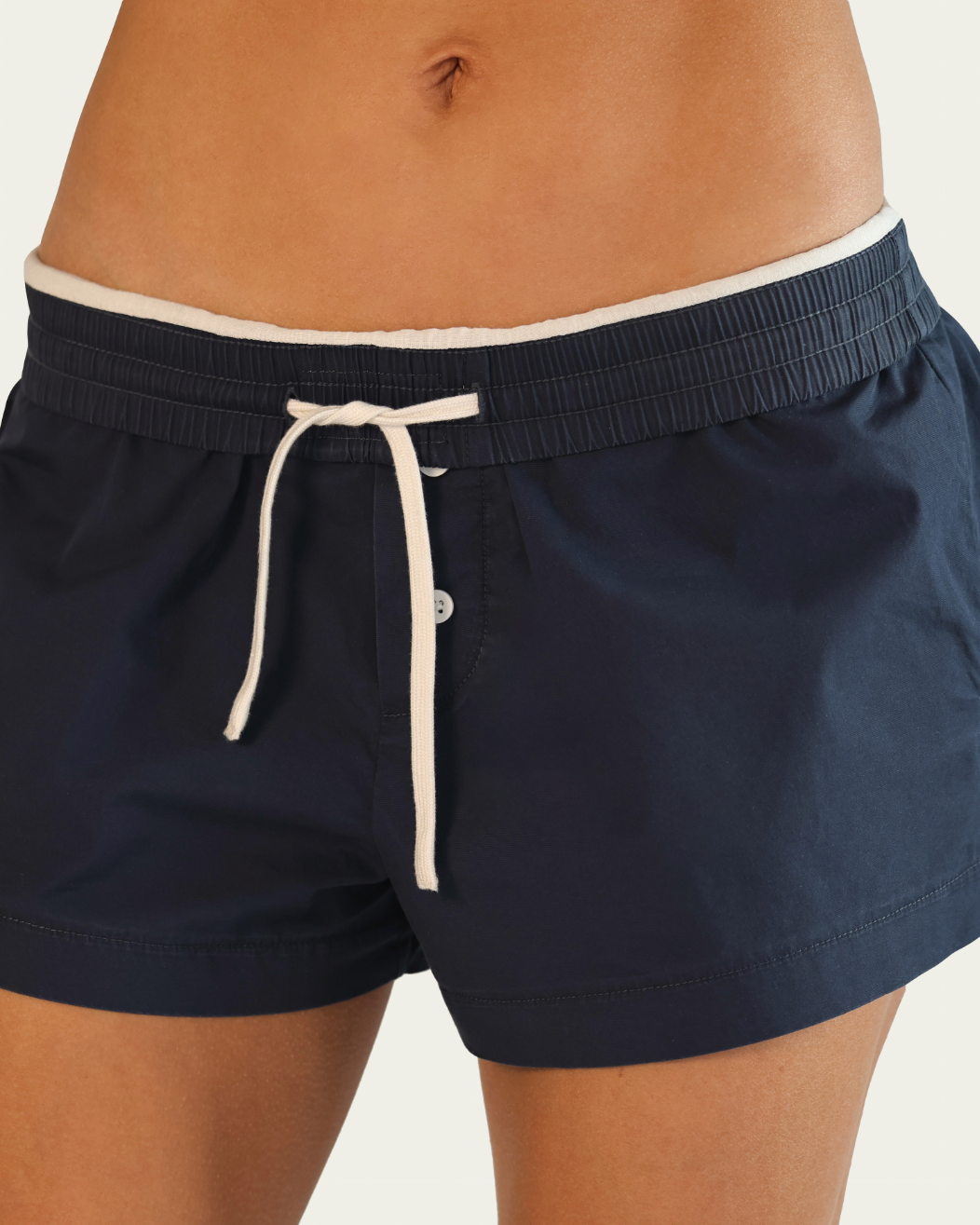 Navy blue shorts with a white drawstring on a neutral background