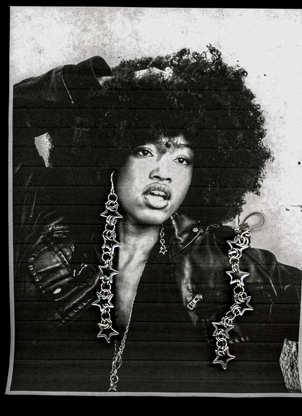 Black and white portrait of a person wearing large, star-shaped earrings.