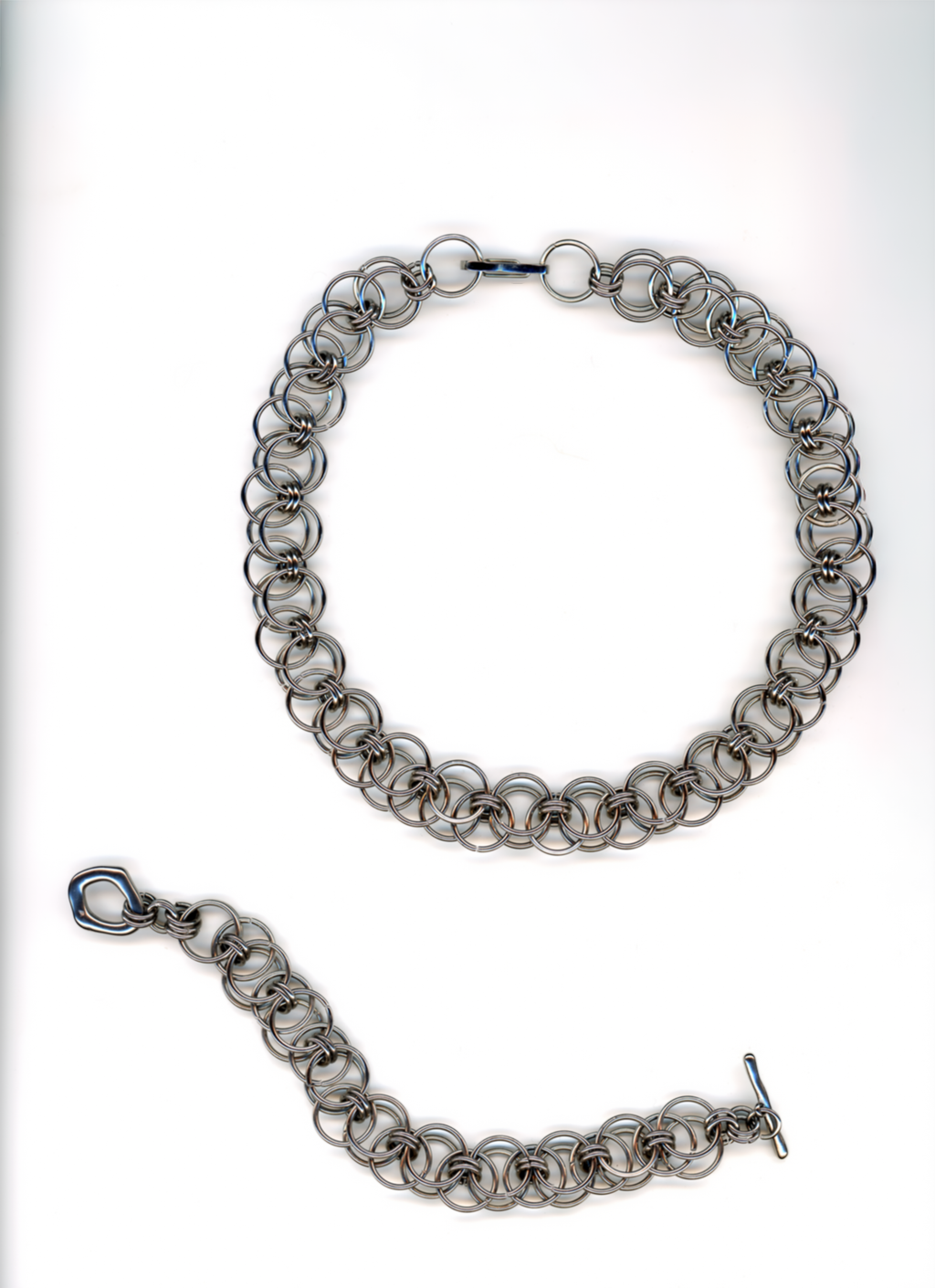 Silver chain bracelet and necklace on a white background