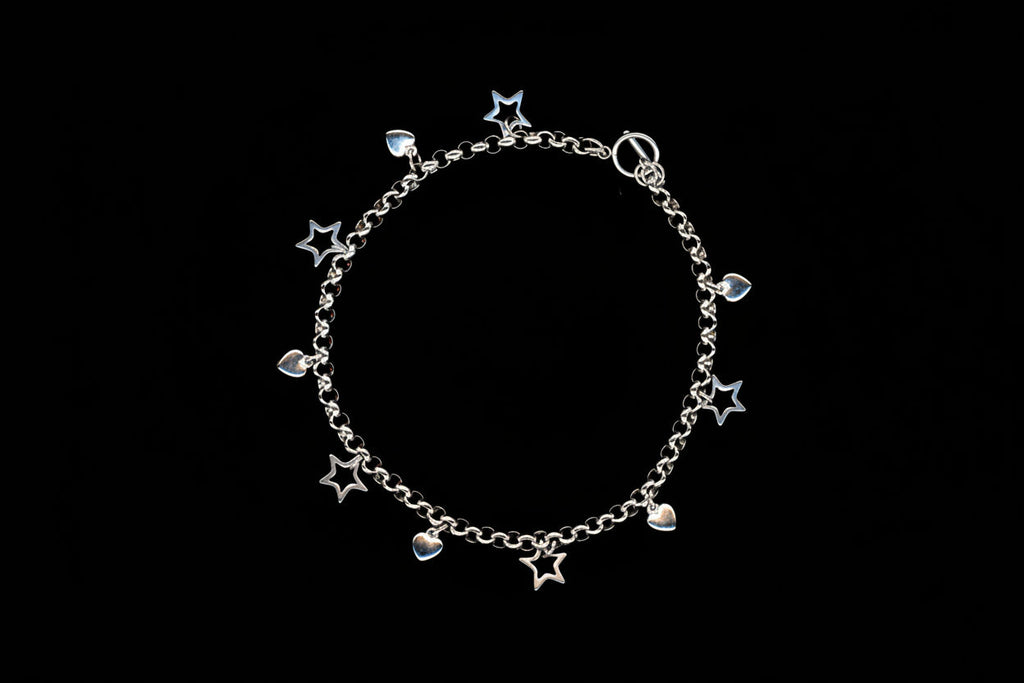 A silver stainless steel charm necklace with heart and star charms, presented against a black background.