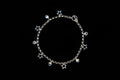 A silver stainless steel charm necklace with heart and star charms, presented against a black background.