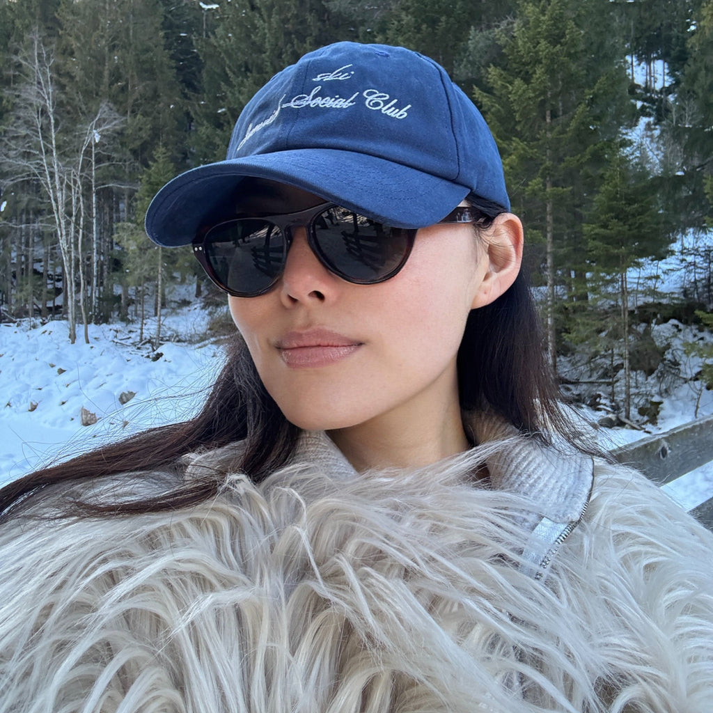 Model wearing Ciren oval tortoiseshell sunglasses and wearing Greenwich Social Club logo baseball cap