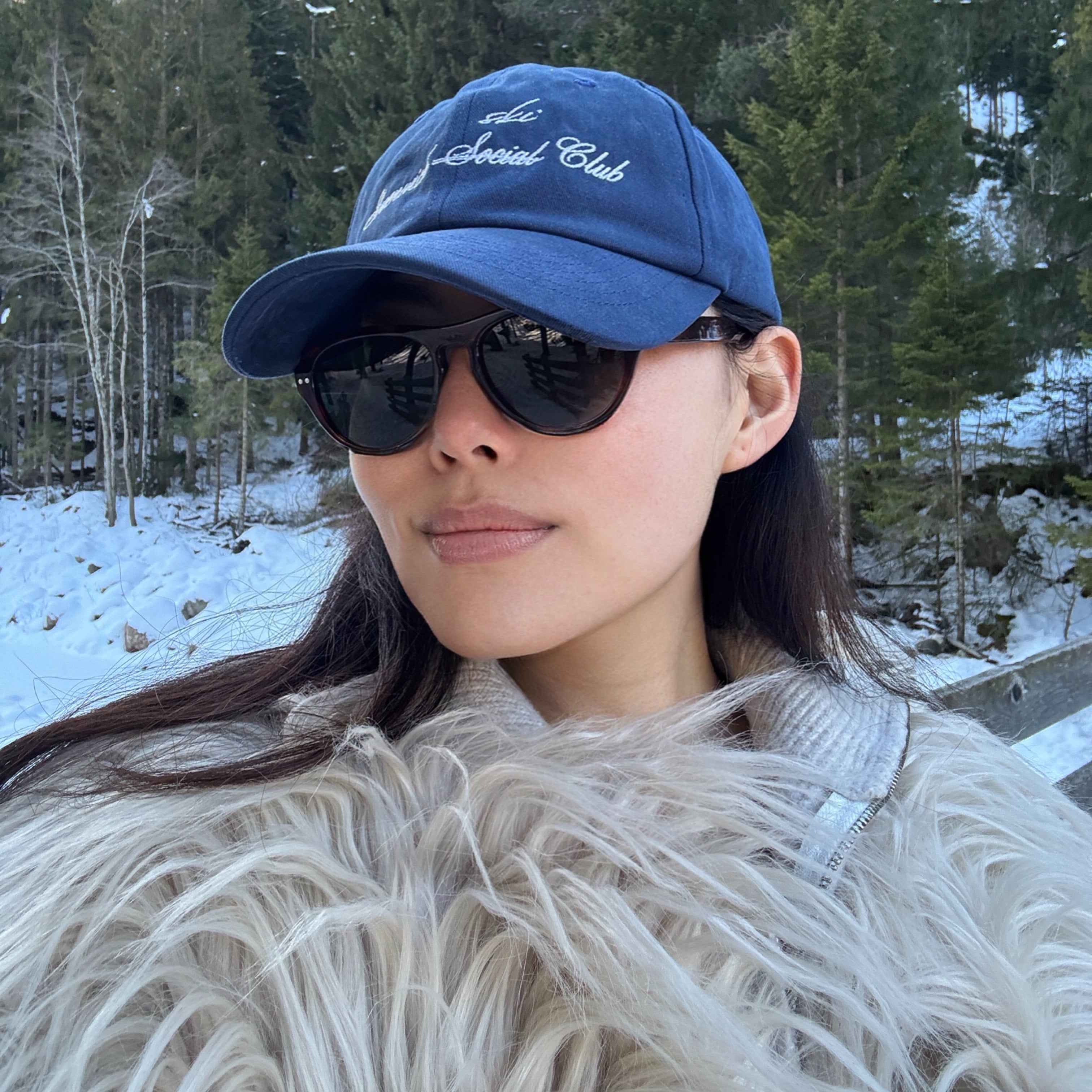Model wearing Ciren oval tortoiseshell sunglasses and wearing Greenwich Social Club logo baseball cap