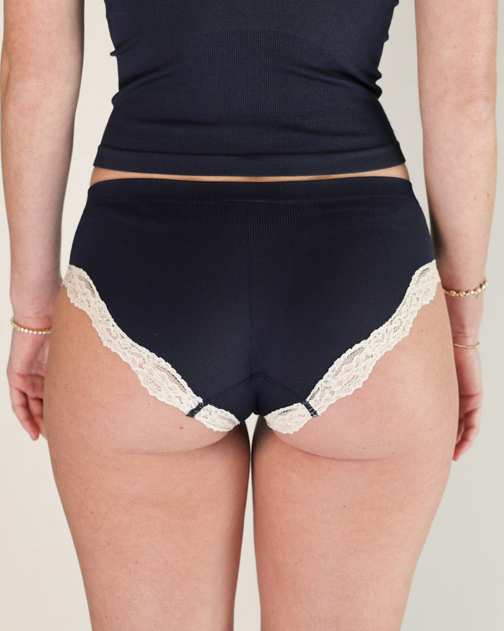 Back view of the Lunetti Luna Brief in Midnight Navy with white lace trim.